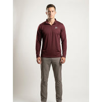 A man modeling a long-sleeve quarter-zip pullover in maroon with a small white logo on the left chest, paired with gray pants, against a light gray studio background.